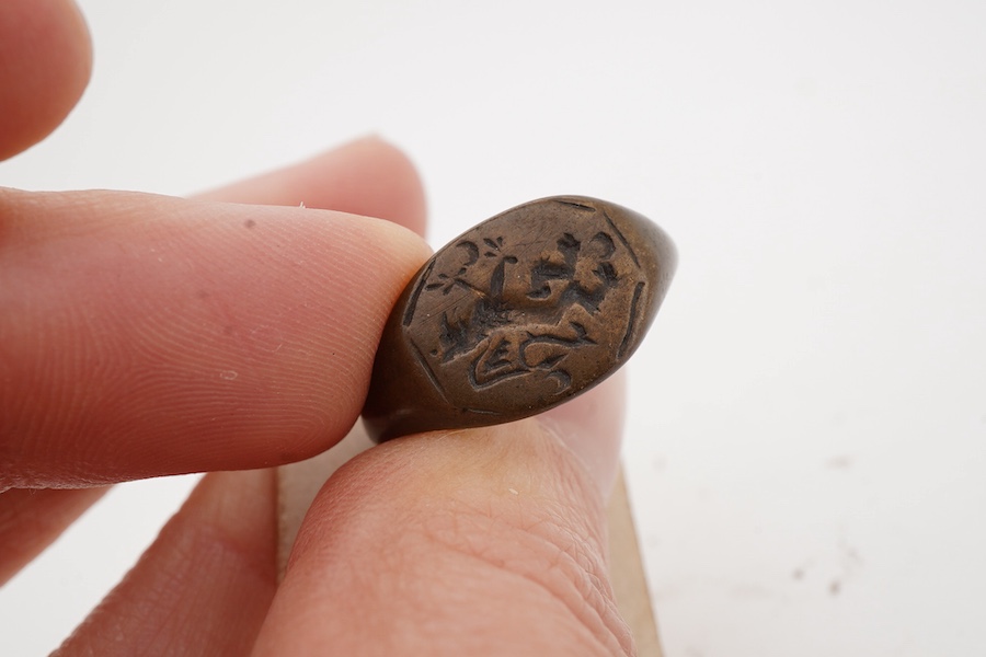 A Tudor bronze heraldic signet ring, England, circa 1500, the octagonal panel depicting a griffon rampant, to a plain band, size L1/2, Provenance: formerly in the collection of Dame Joan Evans (1893-1977), By repute, fro